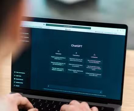 OpenAI is rolling out a Spotify Wrapped-style recap for ChatGPT users The image shows an over-the-shoulder view of a person using a laptop displaying the ChatGPT interface.